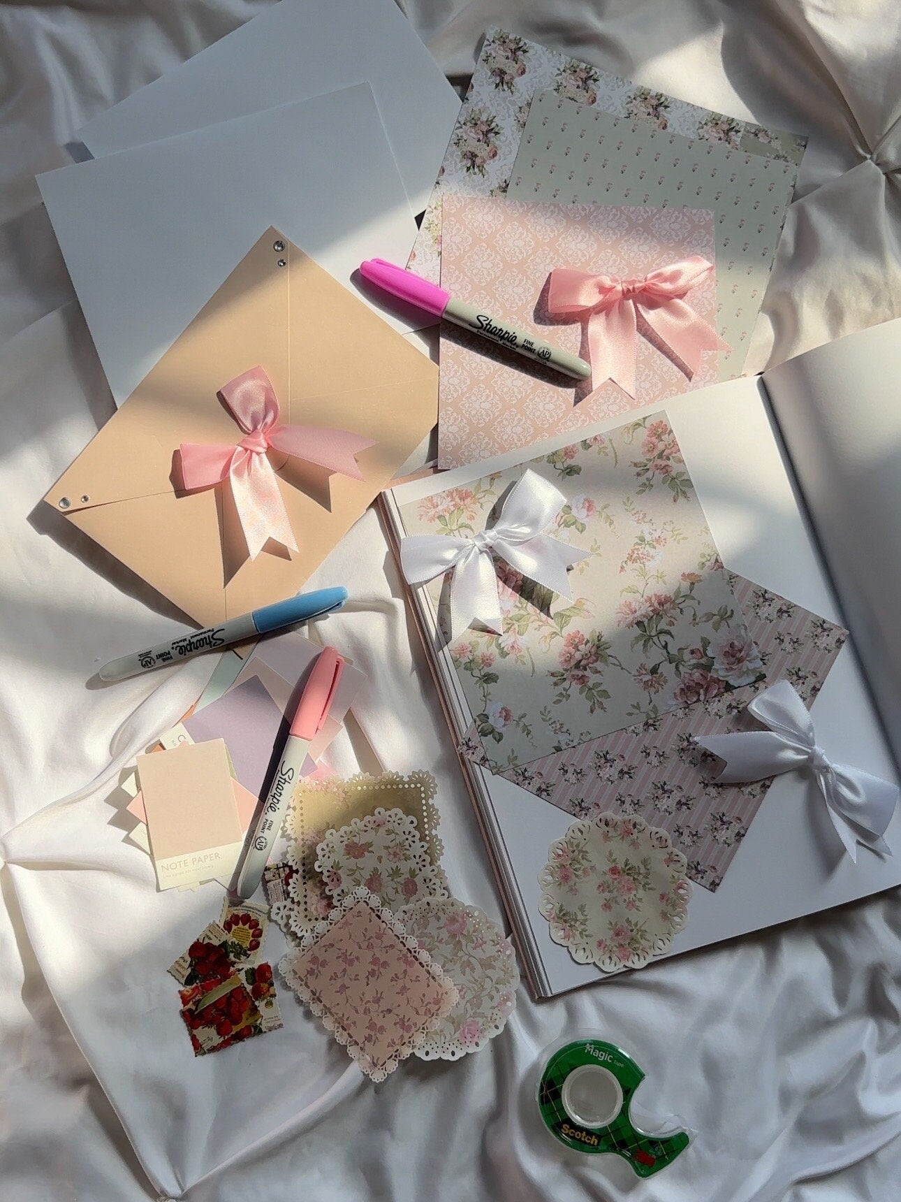 Bows scrapbook kit displayed on top scrapbook page with Sharpie markers and tape for decoration.
