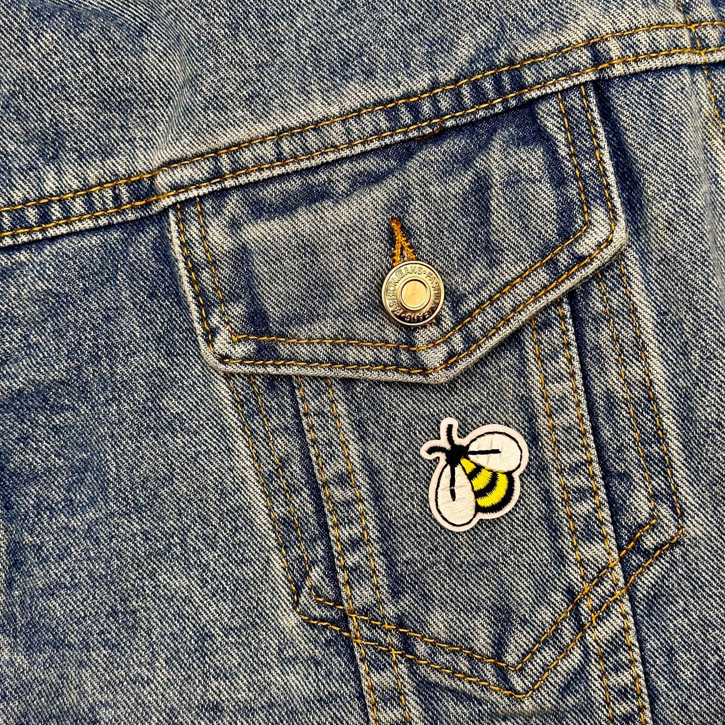 Cute honeybee patch on blue jean jacket pocket.