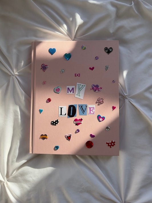 Light pink hardcover scrapbook with newspaper letters reading “My Love”. Decorated with cute girly stickers and jewels.