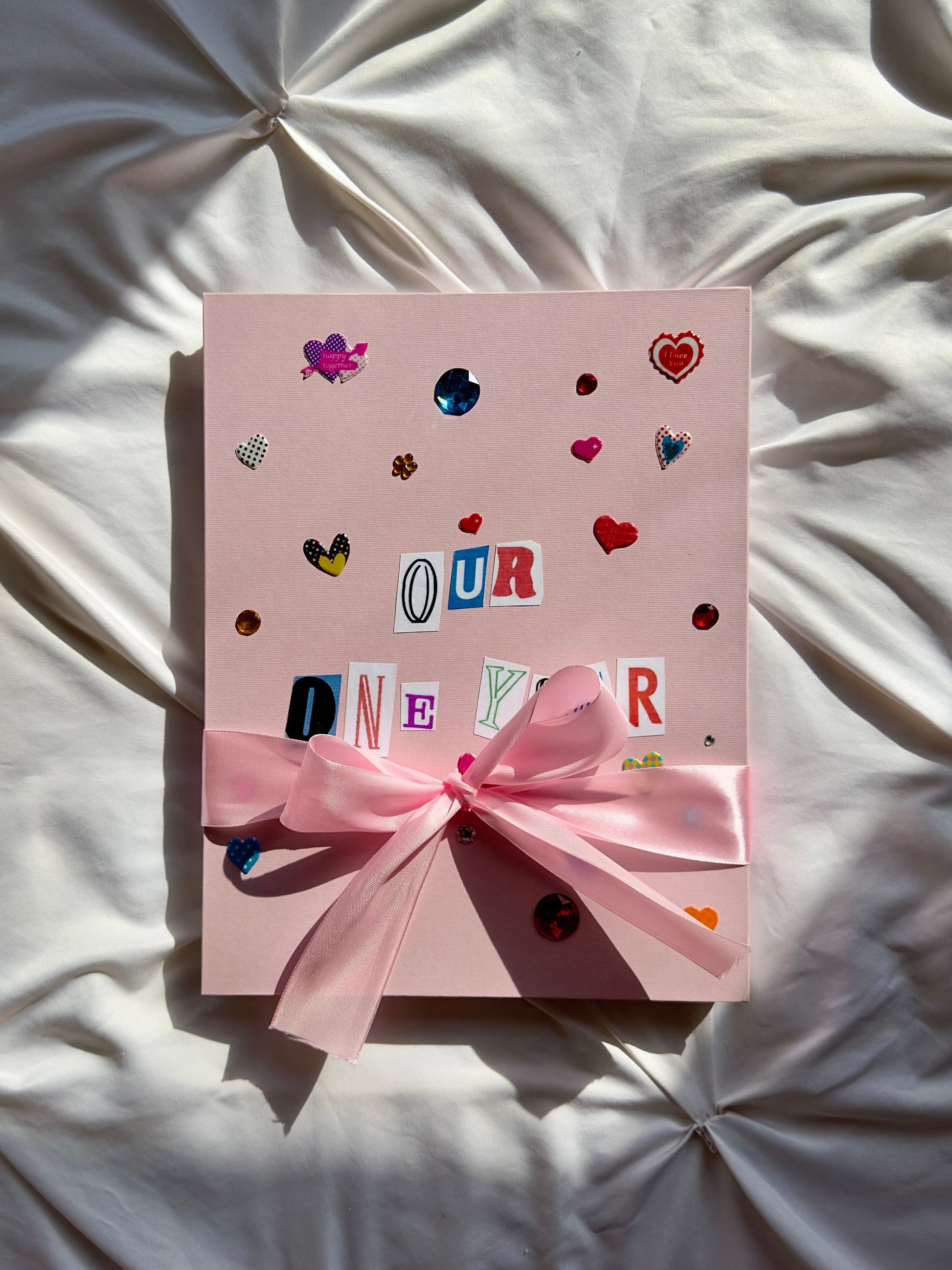 Light pink scrapbook with a big pink bow tied around it.