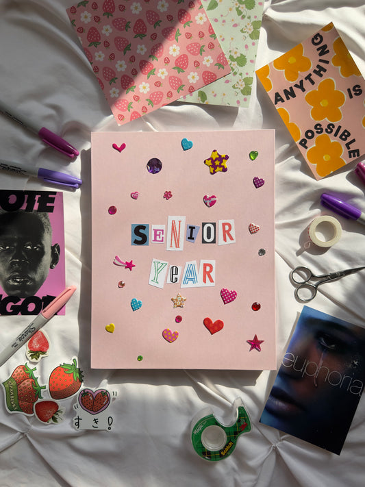 Light pink hardcover scrapbook with newspaper letters reading “Senior Year”. Decorated with heart and star stickers and jewels.