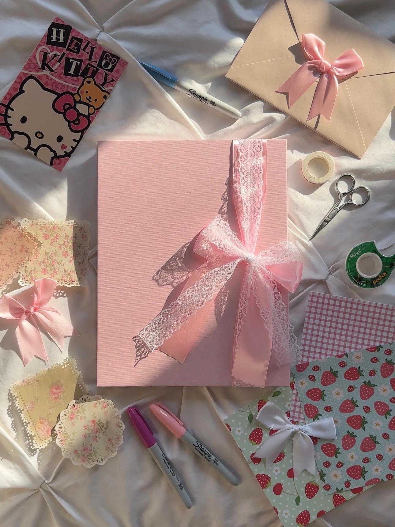 Light pink hardcover scrapbook with pink and white lace bow on cover.