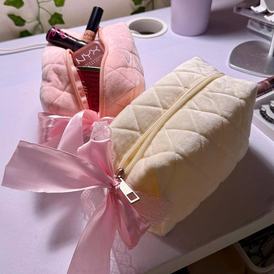Lightweight puff makeup pouch in white and light pink. Cute pink bows tied on pouch zipper.